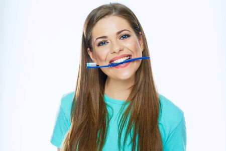 Funny woman face holding toothbrush in mouth. White background.の写真素材