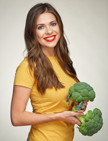 smiling woman with long hair healthy lifestyle portrait with green broccoli. isolatedの写真素材