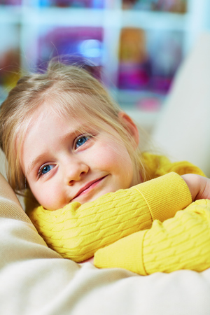 Little girl lying at home. Smiling child. Close up portrait.の写真素材