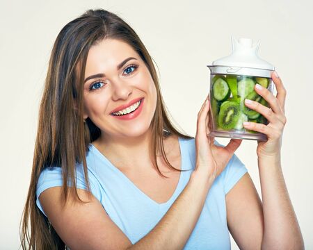 Smiling woman holding blender with smoothy ingredients. Isolated portrait.の写真素材