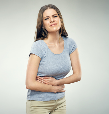 Woman with stomach  pain touching tummy. Isolated portrait.の写真素材