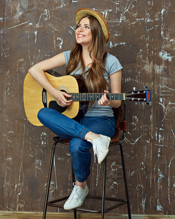 Beautiful girl play music with guitar. Young woman portrait with acoustic guitar.の写真素材