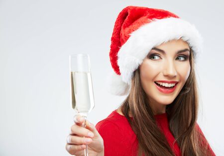 Christmas Santa hat isolated woman portrait hold wine glass. Smiling happy girl on white background.の写真素材