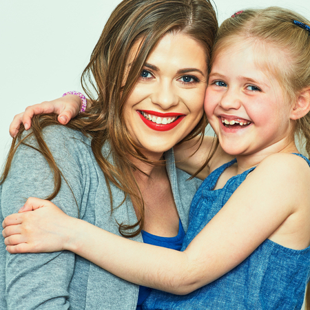 studio isolated portrait of hugging mother and daughter.の写真素材