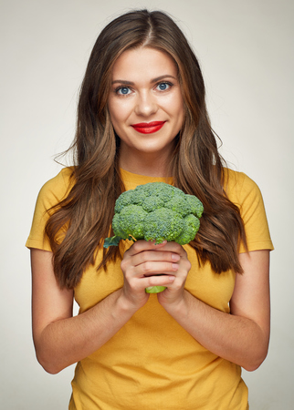 smiling woman with long hair healthy lifestyle portrait with green broccoli. isolatedの写真素材