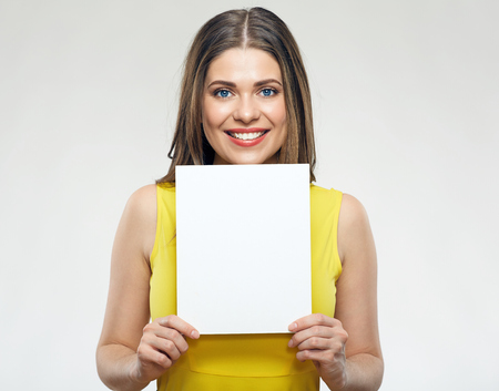 Woman wearing yellow dress holding white sign board.の写真素材