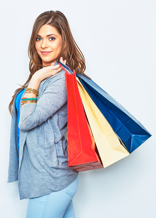 Shopping woman holding bag on shoulder. Smiling pretty girl portrait on white background. Happy woman.の写真素材