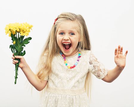 Smiling Girl hold yellow flowers. Fashion child portrait.の写真素材
