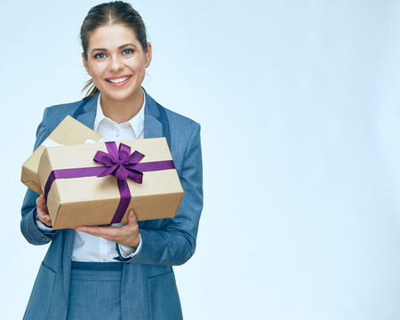 toothy smiling business woman standing with gift box against white background. Isolated portrait. Business suit.の写真素材