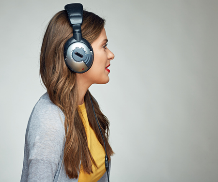 Listening music young smiling woman isolated studio portrait.の写真素材