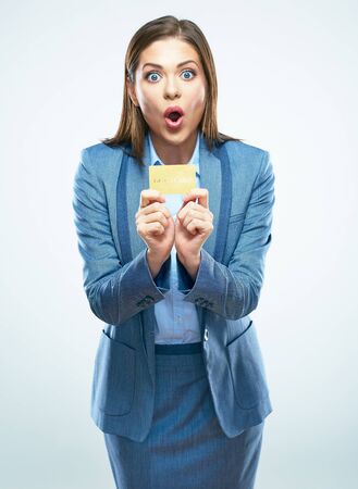 Surprised business woman in suit credit card show. White background isolated.の写真素材