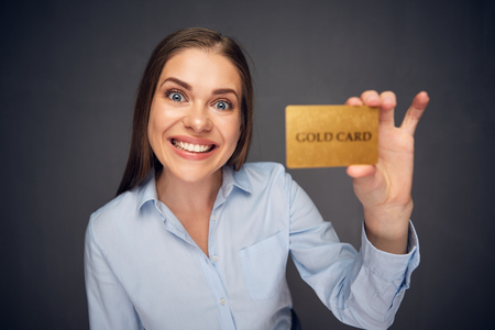 Smiling business woman holding gold plastic bank card. Funny whide angle portrait.の写真素材