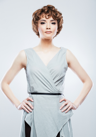 Fashion Style Woman with curly  hair on white background isolated  portrait. Young model posing in studio.の写真素材