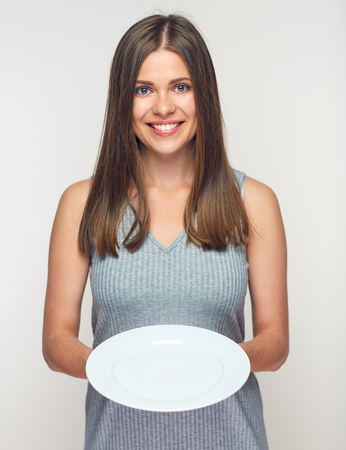 Woman holding white plate. Smiling girl waitress isolated.の写真素材