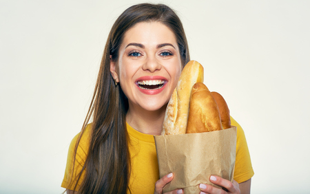 Smiling woman holding shopping bag with bread. Portrait isolated on white background.の写真素材