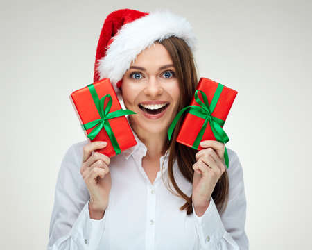 Smiling Business Santa Girl holding two red gifts. Isolated close up portrait.の写真素材