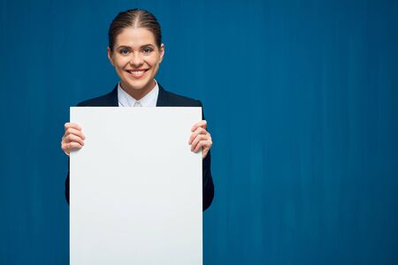 Smiling business woman holding sign card. Portrait on blue background.