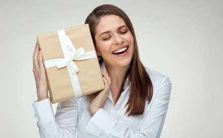 Businesswoman with closed eyes holding gift box. Isolated portrait.の写真素材