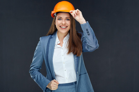 Young woman architect builder wearing gray business suit look successful and confident. Portrait isolated on black wall back.の写真素材