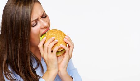Close up portrait of hungry woman eating burger. の写真素材