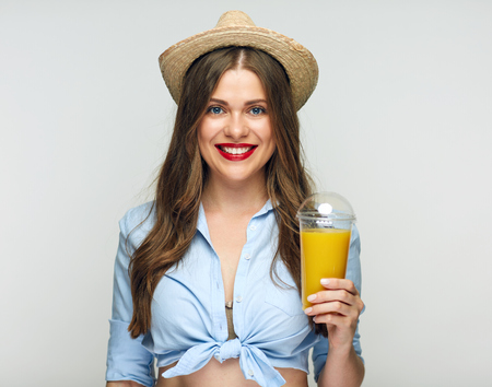 Modern beautiful girl holding orange juice glass. Isolated portrait.の写真素材
