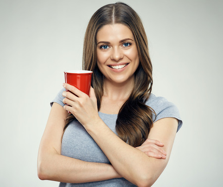 Smiling girl holding big red coffee glass. Isolated studio portrait.の写真素材