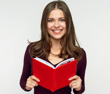 Smiling woman student holding red book. Isolated portrait on white.の写真素材