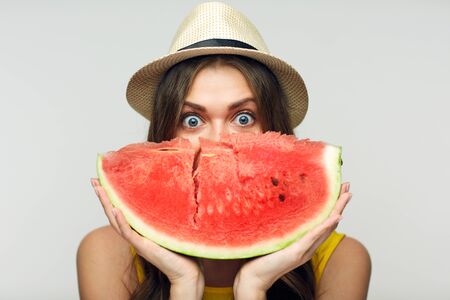 Woman holding red watermelon against face. Isolated portrait.の写真素材