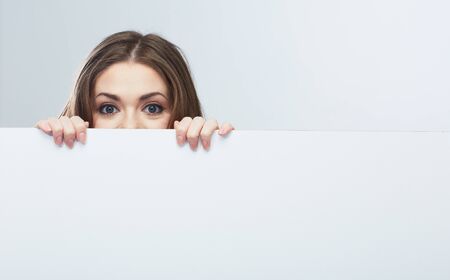 Woman looks out of pure billboard. Isolated.の写真素材