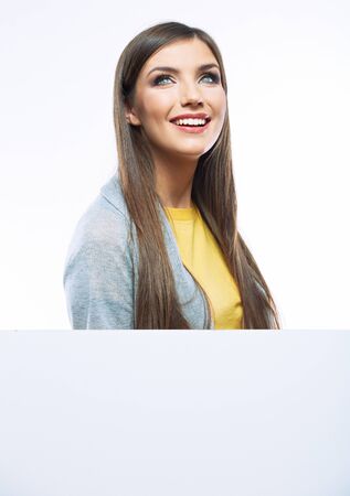 Teenager girl with white blank board. White background isolated portrait of smiling young woman.の写真素材