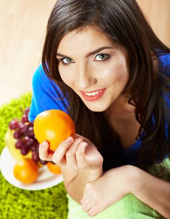 Woman seating on floor with fruits. Female model indoor portrait.の写真素材