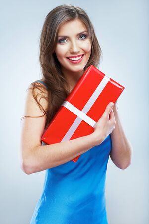 Young smile woman hold red giet box with white ribbon. Isolated studio background female model.の写真素材
