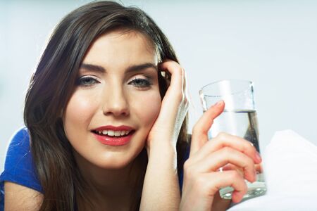 Smiling female model portrait with water glass. Beautiful girl. Young woman drink water.の写真素材