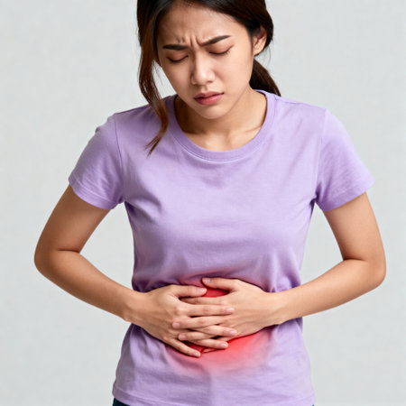 Young Asian Woman Suffering from Severe Stomach Painの素材