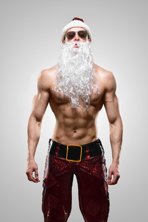 Holidays and celebrations, New year, Christmas, sports, bodybuilding, healthy lifestyle - Muscular handsome sexy Santa Clausの写真素材