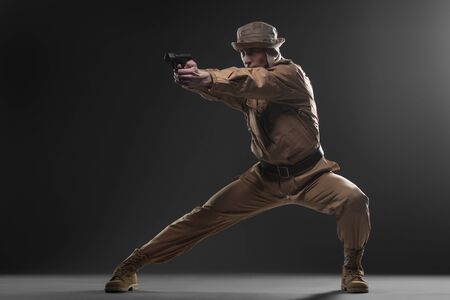 Military, war, conflict, soldiers - Special forces soldier with a gun takes aim on dark background