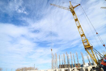 House construction. Photos of high-rise construction cranes and an unfinished house against a blue...