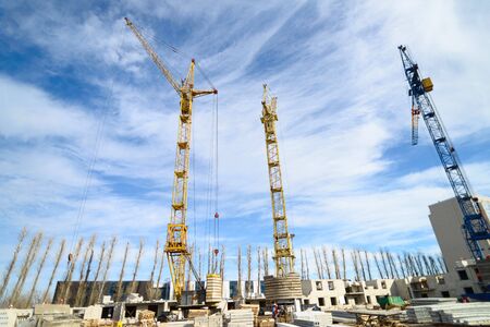 House construction. Photos of high-rise construction cranes and an unfinished house against a blue...