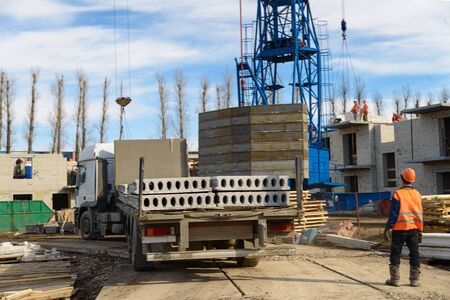 House construction. Photos of high-rise construction cranes and an unfinished house against a blue...