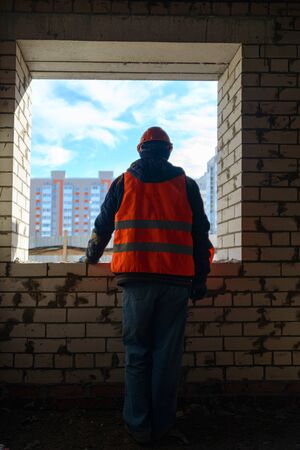 House construction. View from the window of an unfinished house on new multi-storey buildings and blue sky. Crisis in the construction industry.の写真素材