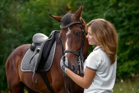portrait of a pretty young girl with a browne horse