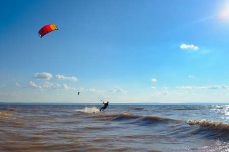 Kiteboarding. A kite surfer rides the waves. A middle-aged man enjoys riding the waves on a kite.