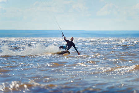 Kiteboarding. A kite surfer rides the waves. A middle-aged man enjoys riding the waves on a kite.