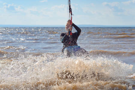 Kiteboarding. A kite surfer rides the waves. A middle-aged man enjoys riding the waves on a kite.
