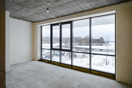 The room is under construction with a rough finish, plastered walls, concrete floor. Wiring of...