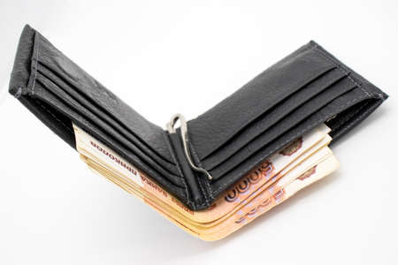 A purse with money on a white background and a hand that counts bills.