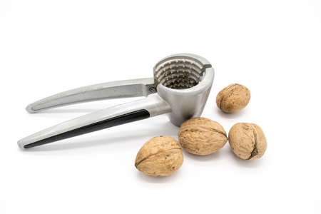 Walnuts on a white background, broken by a nutcrackerの写真素材