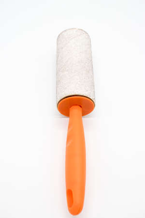 Cleaning sticky roller with orange handle on white backgroundの写真素材