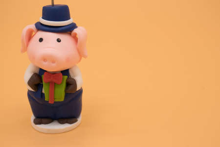 Christmas toy in the form of a pig isolated on yellow backgroundの写真素材