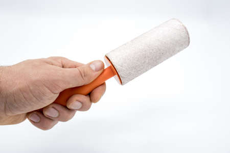 Cleaning sticky roller with orange handle on white background
